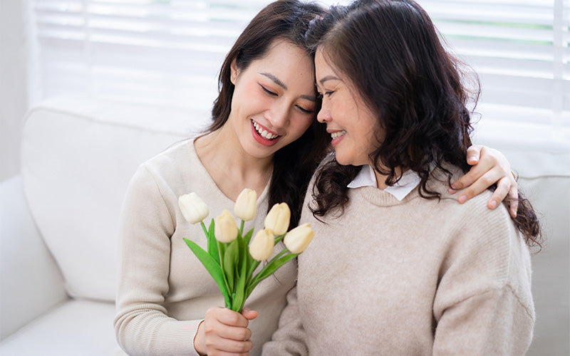 Daughter giving her mother flowers for Women's Day