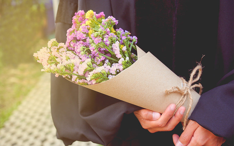 Graduate holding simple colorful flower bouquet
