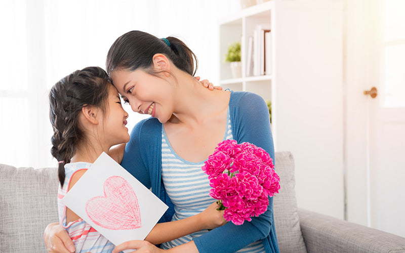 Mother and daughter celebrating a new home with pink carnations