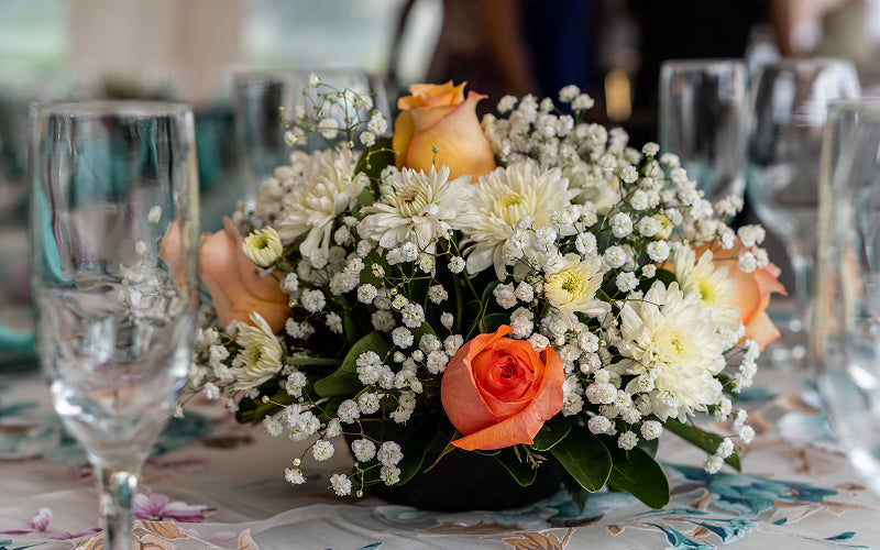 Vibrant flower centrepiece styled on a dining table layout.