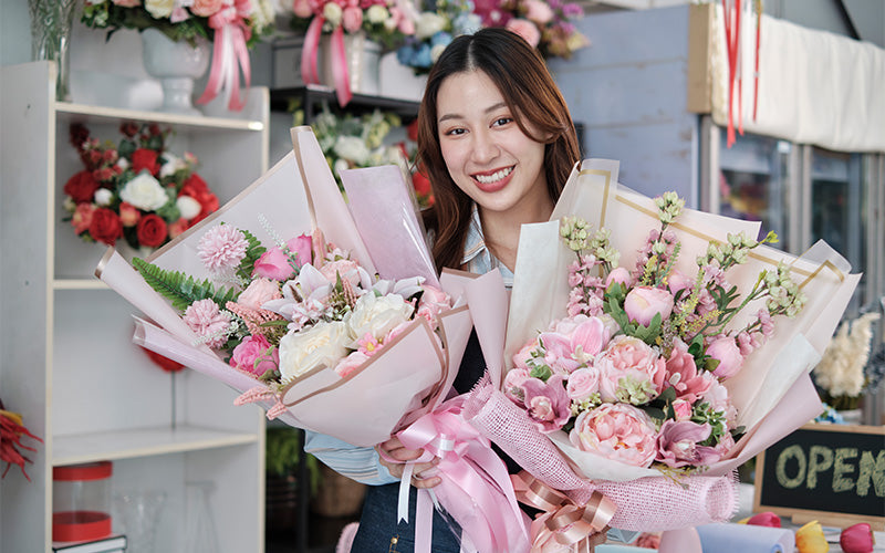D'Spring florist holding pink bouquets to congratulate a promotion.