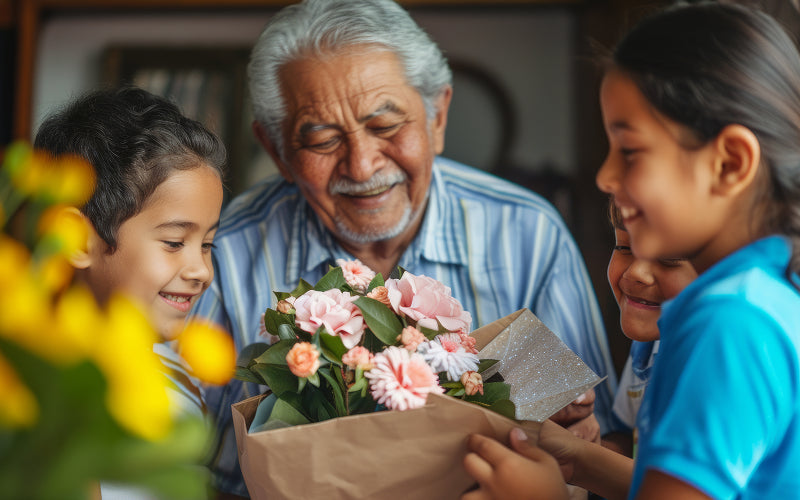 Happy grandchildren giving a bouquet of flowers to grandfather.