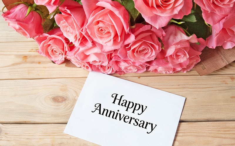 Pink roses with a happy anniversary card